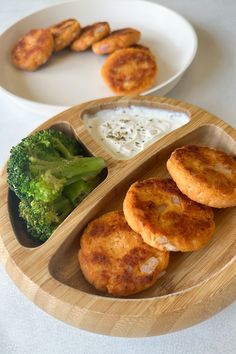 some food is sitting on a wooden plate with broccoli and other foods in the background