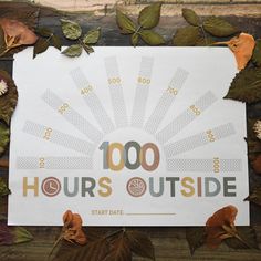 a sign that reads, 100 hours outside with leaves around it on a wooden surface