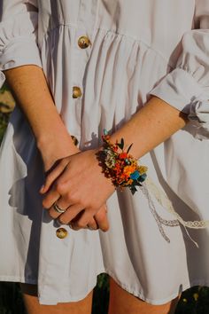 a close up of a person's hand wearing a bracelet with flowers on it