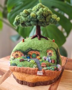 a small green house on top of a wooden table