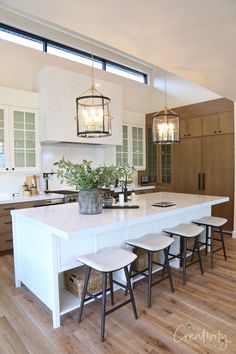 a kitchen island with four stools in front of it