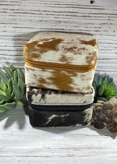 three different types of animal print bags sitting next to succulents