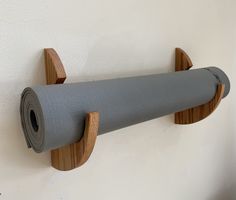 a roll of yoga paper is hanging on the wall next to a rolled up mat