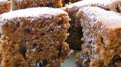 several pieces of cake on a plate with powdered sugar and raisin toppings