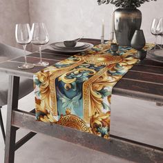 the table runner is decorated with an ornate design and gold accents, along with wine glasses