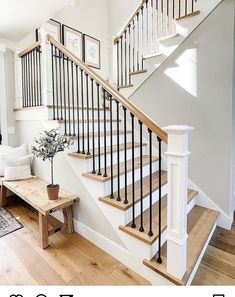 a living room filled with furniture and a stair case next to a wooden table on top of a hard wood floor