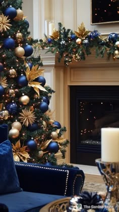 a living room with a christmas tree decorated in blue and gold ornaments, candles and a fireplace