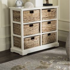 a white dresser with wicker baskets on top and a clock in the corner next to it