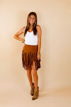 Elevate your wardrobe with our Pep Into Your Step Fringe Skirt! This beauty will have you looking stylish and confident with the eye-catching zig zag fringe on the bottom. Get ready to turn heads and move with grace. Show off your style! Fringe reaches 7 inches below skirt length. Arté is wearing a size small. Size Suggestions: Small: 2-4 | Waist: 26 inches around | Length: 13.5 inches Medium: 6-8 | Waist: 29 inches around | Length: 14.5 inches Large: 10-12 | Waist: 32 inches around | Length: 15 Fall Festival Fringe Skirt, Trendy Fringe Skirt, Brown Fringe Mini Skirt, Bohemian Brown Bottoms With Fringe, Bohemian Brown Fringe Bottoms, Chic Brown Fringe Skirt, Suede Fringe Skirt, Giddy Up Glamour, Fringe Skirt