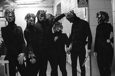 five people in masks standing next to each other