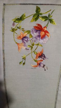 an embroidered piece of cloth with flowers on it