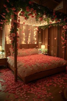 a bed with rose petals on the floor and lights in the room above it that are lit up