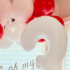 some balloons are hanging from the ceiling in front of a sign that says, be oh my