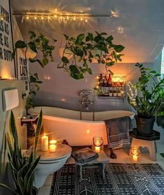 a bathroom with plants and candles in the bathtub, on display at an indoor event