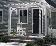 a porch with two rocking chairs and a white trellis on the side of it