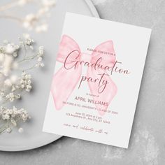 a pink bow on top of a white plate next to some baby's breath flowers