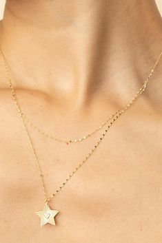 Featuring a doubled 14k gold mirror chain, our Starburst Layered Necklace offers a sleek layered look without the work. A cubic zirconia heart shimmers within a diamond cut solid gold star for a pendant that shines bright day or night! Metal: 14k Yellow Gold Chain Weight and Thickness: 2.1 Grams - 0.9mm Thick Pendant Dimensions: 18mm long, 16mm wide Length: Chain 1, 15-16 Inches Long, Chain 2, 17-18 Inches Long Stones: White Cubic Zirconia Stones Origin: Crafted in Vicenza, Italy Delicate Double Chain 14k Gold Jewelry, Delicate 14k Gold Double Chain Jewelry, 14k Gold Double Chain Layering Jewelry, 14k Gold Double Chain Jewelry For Layering, Vicenza Italy, Gold Starburst, Yellow Gold Chain, Gold Star, Layered Necklace