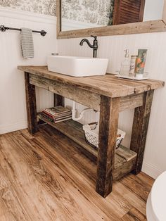 a bathroom with a sink, mirror and wood flooring in the middle of it