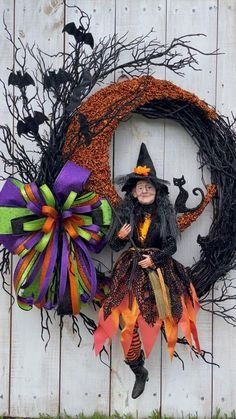 a halloween wreath with a witch sitting on it