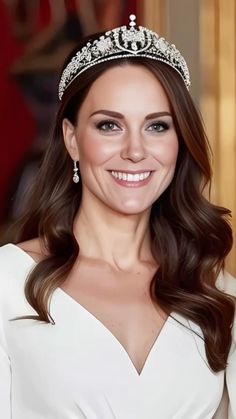 a woman wearing a tiara and smiling at the camera with her hair in half up