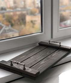 a wooden cutting board sitting on top of a window sill