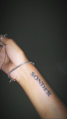 a person's arm with a tattoo on it that says, sonder written in cursive font