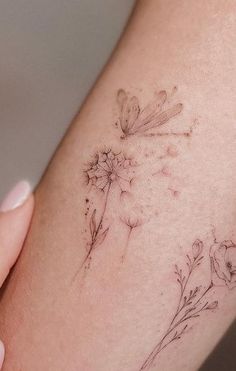 a woman's arm with a flower tattoo on the left side of her body