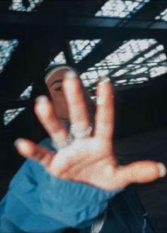 a person holding their hand up in the air with one hand out to show two fingers