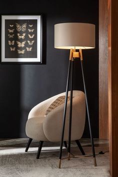 a lamp that is on top of a table next to a chair in a room