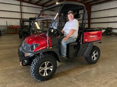 a man sitting in the back of a red golf cart