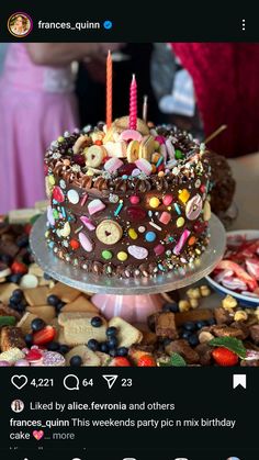 a birthday cake with candles on top of it and lots of candies around the edges