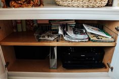 the shelves are full of books, magazines and other items in baskets on top of them