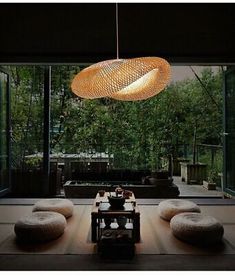 a living room filled with lots of furniture and a large light hanging from the ceiling