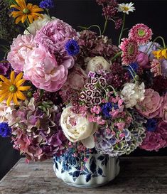 a vase filled with lots of different colored flowers