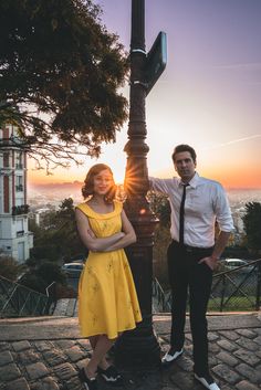 a man and woman standing next to a street light