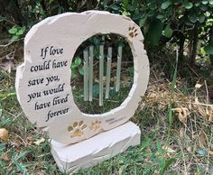 a stone sculpture with a dog's paw print on it and a quote about love