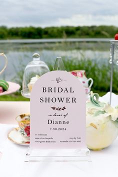 a table topped with plates and cups filled with cake next to a sign that says bridal shower