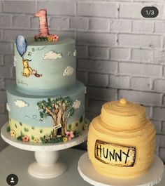 two cakes with winnie the pooh designs on them, one is blue and the other is yellow