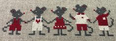 the cross stitch pattern shows several people in red and white outfits, with one person standing behind them