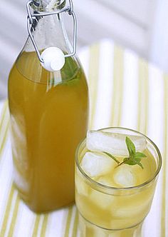 a bottle and glass filled with liquid sitting on a table