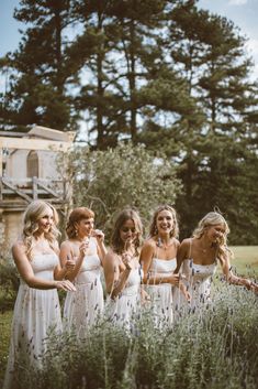 the bridesmaids are laughing together in their wedding dresses and flower crowns at this outdoor ceremony