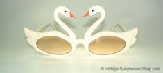 two white swans wearing sunglasses with brown lenses