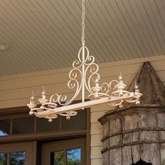 a white chandelier hanging from the ceiling in front of a door with windows