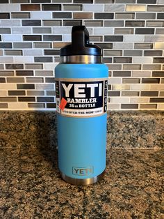 a yeti water bottle sitting on top of a counter next to a tiled wall