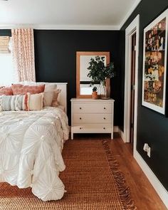 a bedroom with black walls and white bedding