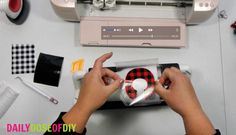 someone is working on an object in front of a sewing machine and other crafting supplies