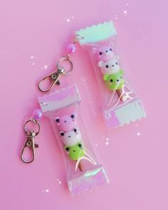 two keychains are attached to each other on a pink background