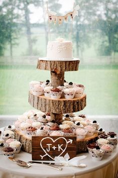 a wedding cake and cupcakes on a table