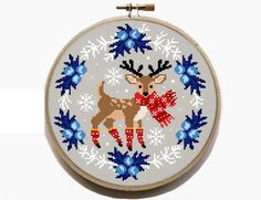 a cross stitch pattern with a deer and snowflakes in the hoop on a white background