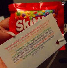 a person holding up a bag of skittles in their left hand and a note attached to it